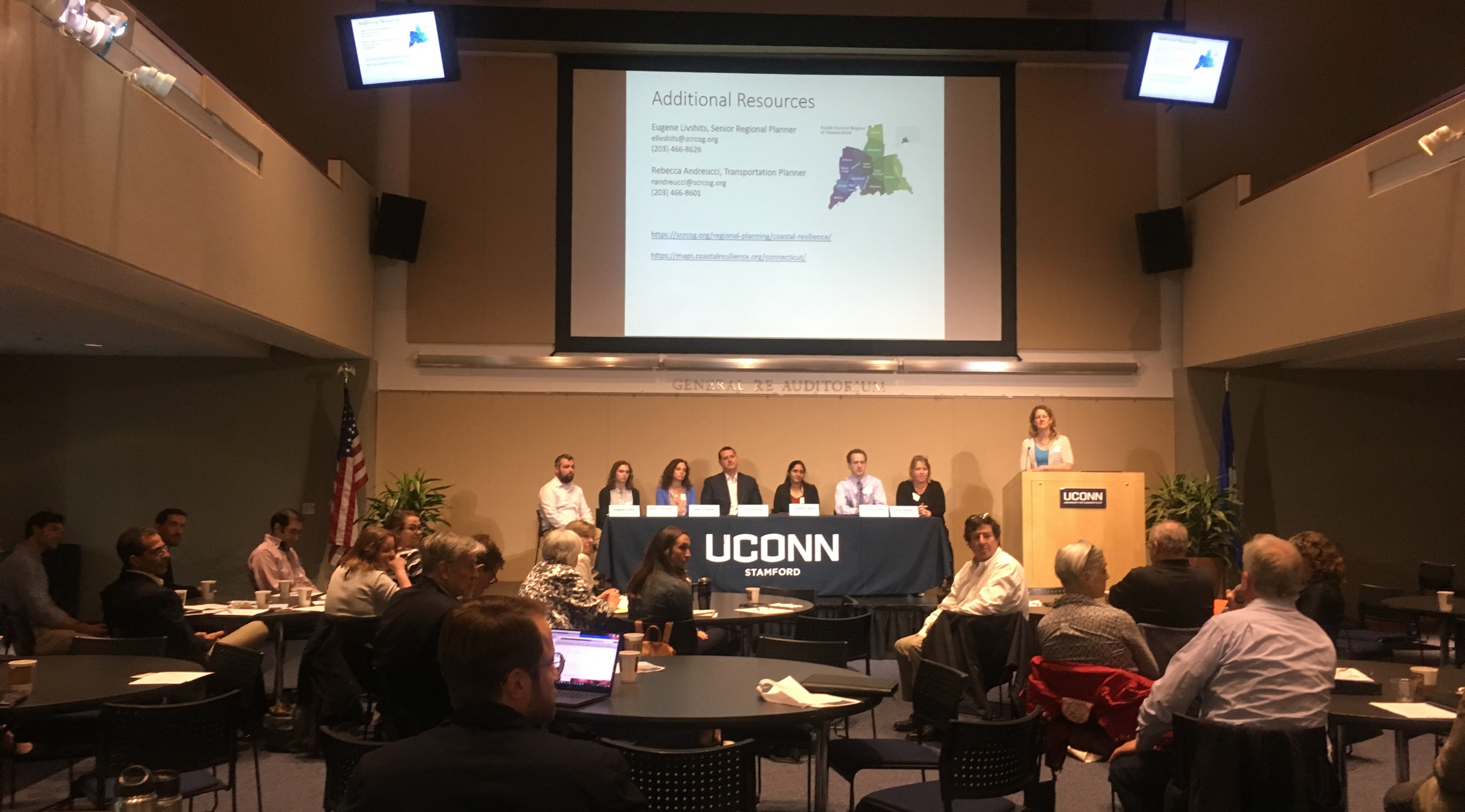 An auditorium with panel and UConn Stamford table sign. The Connecticut Institute for Resilience and Climate Adaptation (CIRCA) hosted event.